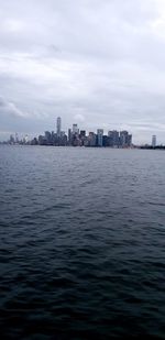 Scenic view of sea by buildings against sky