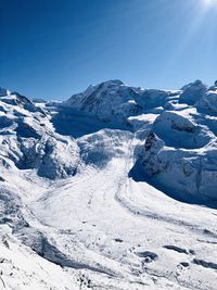 Scenic view of snowcapped mountains against clear blue sky