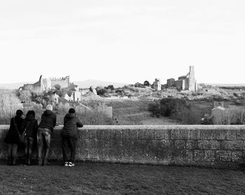 Rear view of people looking at town square against clear sky