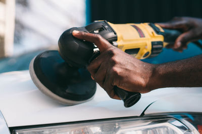 Cropped hand of man repairing car