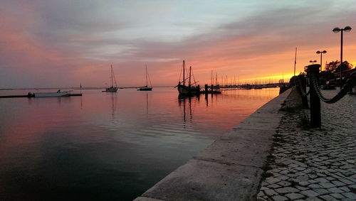 Scenic view of sea against cloudy sky at sunset