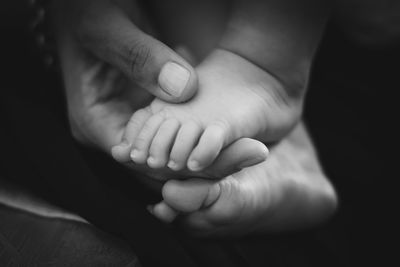 Close-up of mother hand holding baby feet