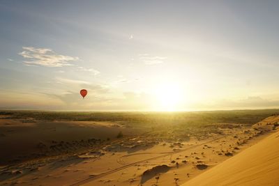 Hot air balloon flying over desert 