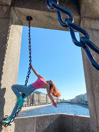 Low section of woman swinging at playground