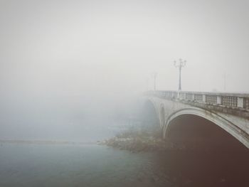 Ponte della vittoria over river against sky during foggy weather