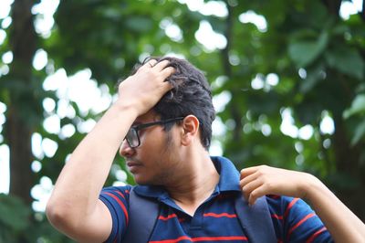 Low angle view of man with hand in hair