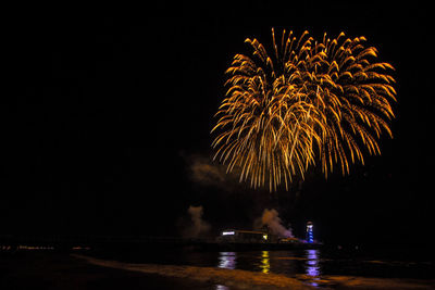 Firework display over river at night