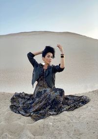 Young woman sitting on the beach