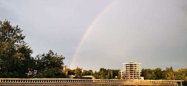 Low angle view of rainbow over building against sky