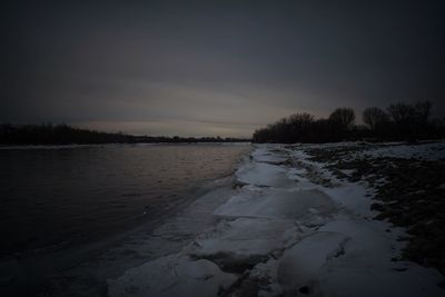 Scenic view of frozen river against sky during sunset