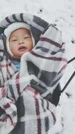 High angle view of toddler wrapped in blanket