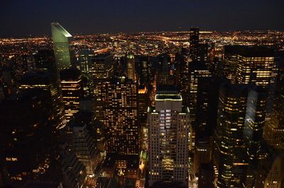 Illuminated cityscape against sky at night