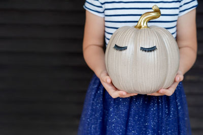 Midsection of woman holding pumpkin