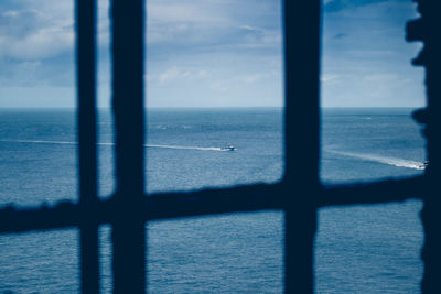 Scenic view of sea against sky seen through window