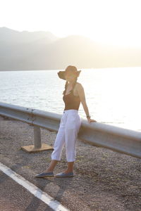 Full length of woman standing on sea shore against sky