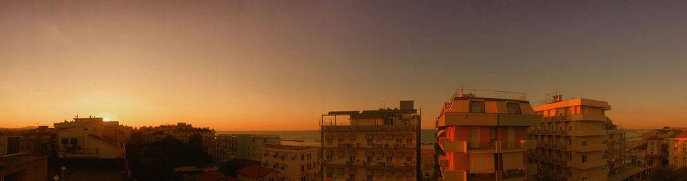 View of buildings in town at sunset