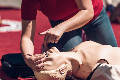 Low section of woman demonstrating on cpr dummy