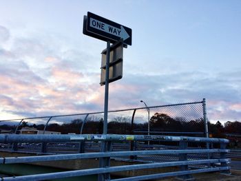 Information sign against sky during sunset