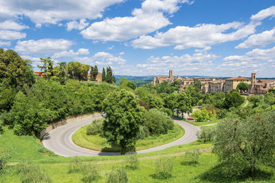 Panoramic shot of road by trees in city against sky