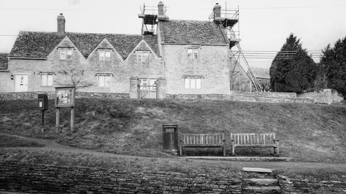 Old building by field against sky