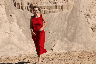 Portrait of smiling young woman standing on land