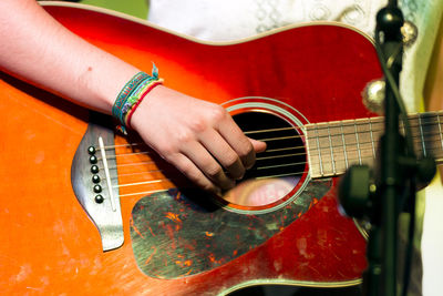 Midsection of man playing guitar