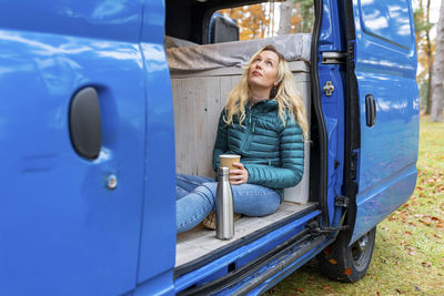 Full length of woman sitting in car