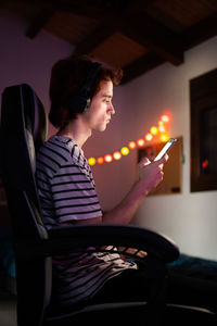 Man using mobile phone while sitting in darkroom