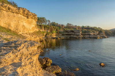 Scenic view of rocks on beach against sky