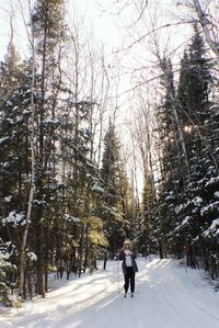 Rear view of man walking on snow covered road