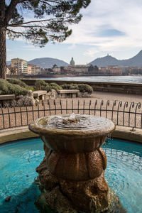 View of fountain by swimming pool in city