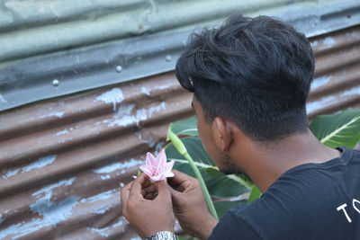 Close-up of young man holding flower