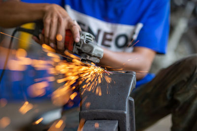 Midsection of man working on metal