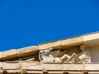 Low angle view of a statue against blue sky