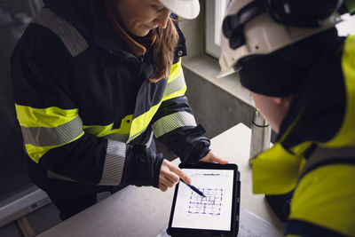 Engineers checking plans on digital tablet