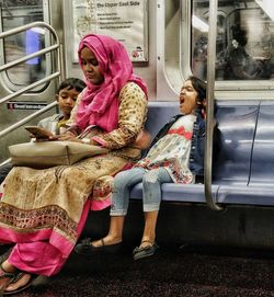 Young woman sitting on escalator in train