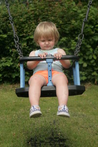 Girl sitting on swing at park
