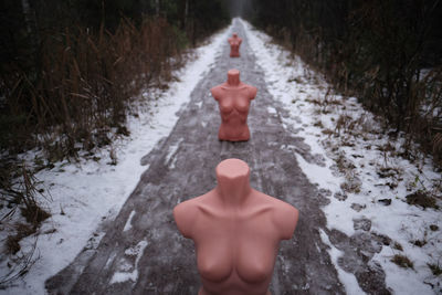 Rear view of shirtless man on snow covered road