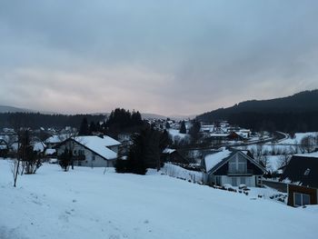 Snow covered buildings against sky