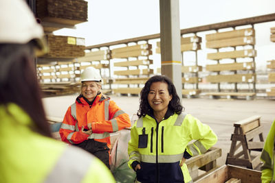 Smiling mature female blue-collar worker with colleagues at industry