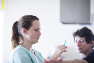 Nurse with syringe and a patient female