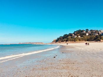 Scenic view of beach against clear blue sky