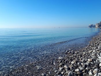 Scenic view of sea against clear blue sky