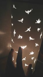 Low angle view of hands against illuminated lights