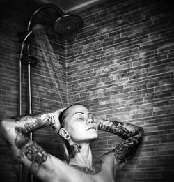 Woman with tattoos taking shower