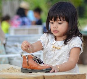 Cute girl playing with shoe in playground