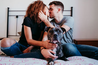 Young couple with dog sitting at home