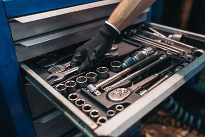 Cropped hand of man holding wrench in tool box