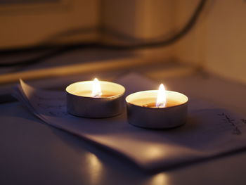 Close-up of burning tea light candles on table