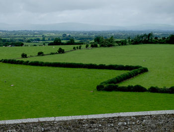 Scenic view of field against cloudy sky